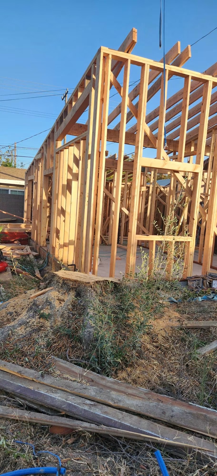 ADU open-stud wood framing with rafters visible against blue sky