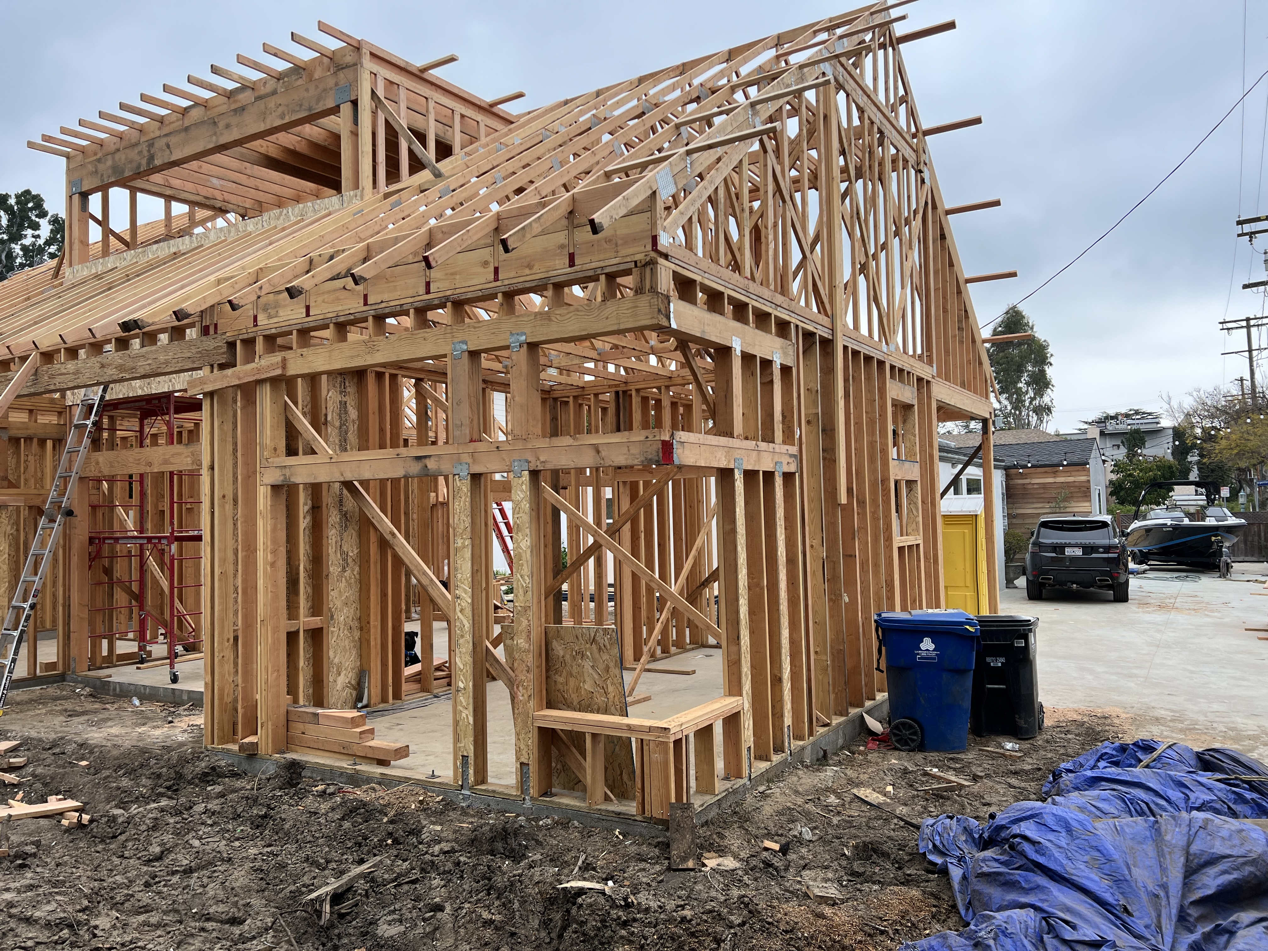ADU framing with partially sheathed roof and dirt ground