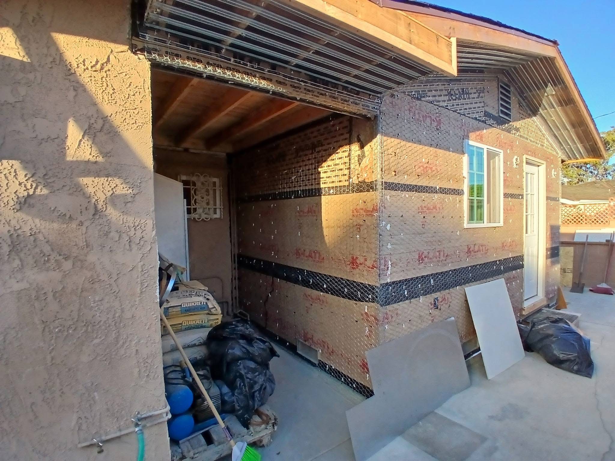 ADU exterior wall section opened for remodeling with exposed studs and wire lath
