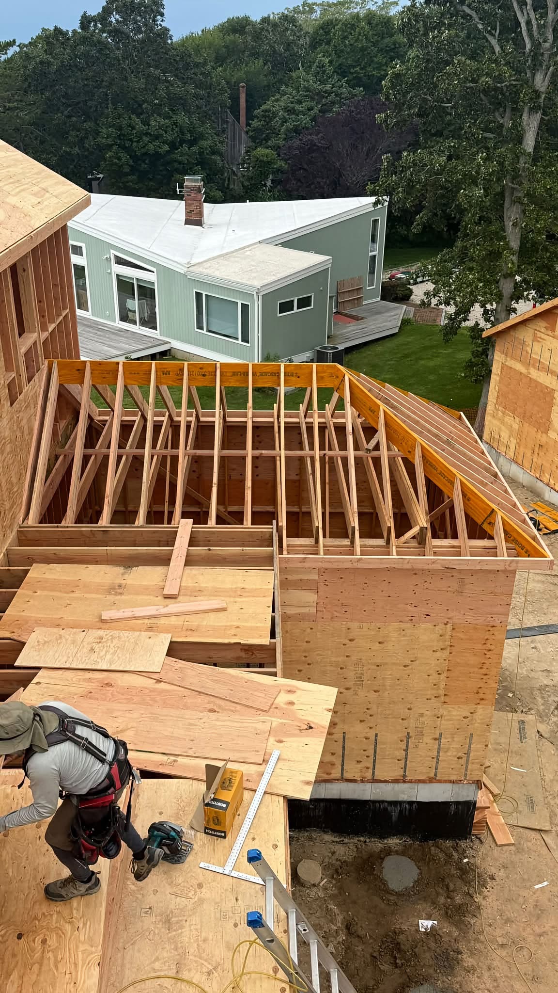 Elevated view of ADU roof framing with LVL ridge beam and worker