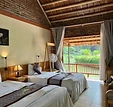 Rustic twin bedroom with vaulted ceiling and balcony at Tam Coc Nature