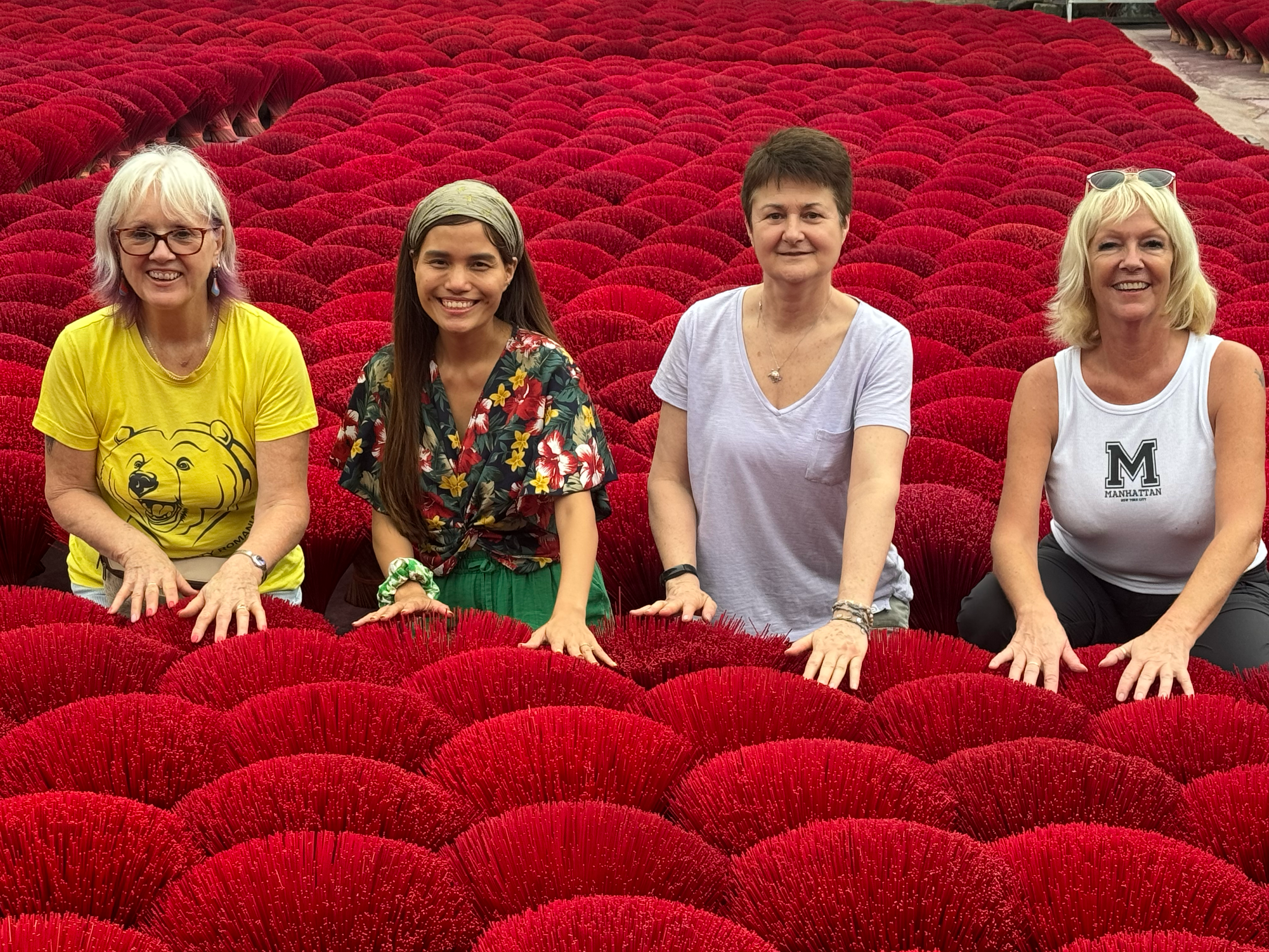 Travellers posing among red incense sticks in Vietnam