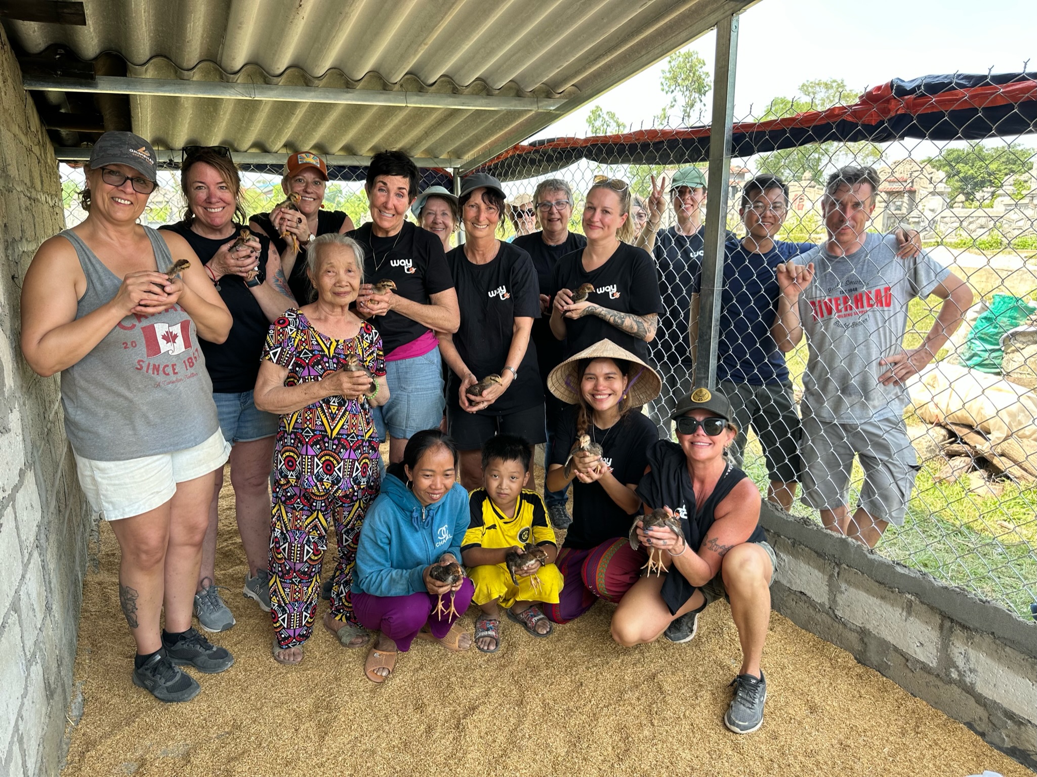 The whole group holding chicks at the build site