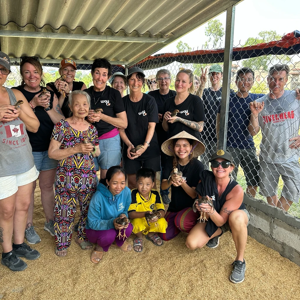 Whole group holding chicks at the build site