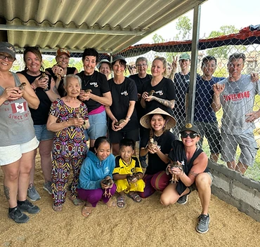 Whole group holding chicks at the build site