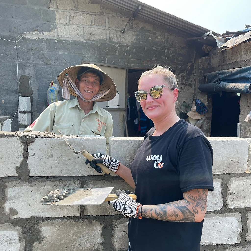 Volunteer and local builder with a trowel