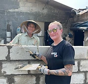 Volunteer and local builder with a trowel