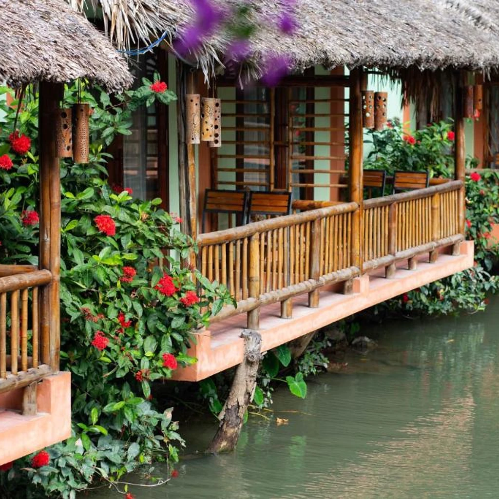 Thatched bungalows on stilts over the water at Tam Coc Nature