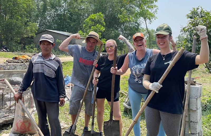 Way To Travel team posing together with shovels after a build day
