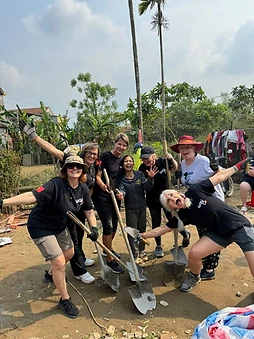 Way To Travel volunteer posing with a shovel at the build site