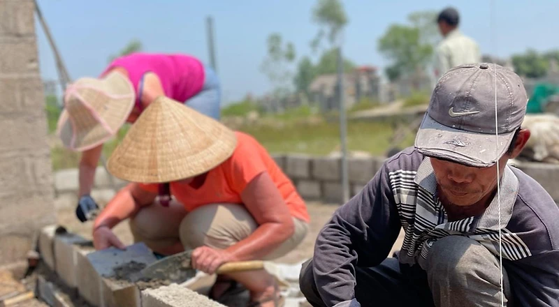 Volunteers building a wall together on a Give Back project