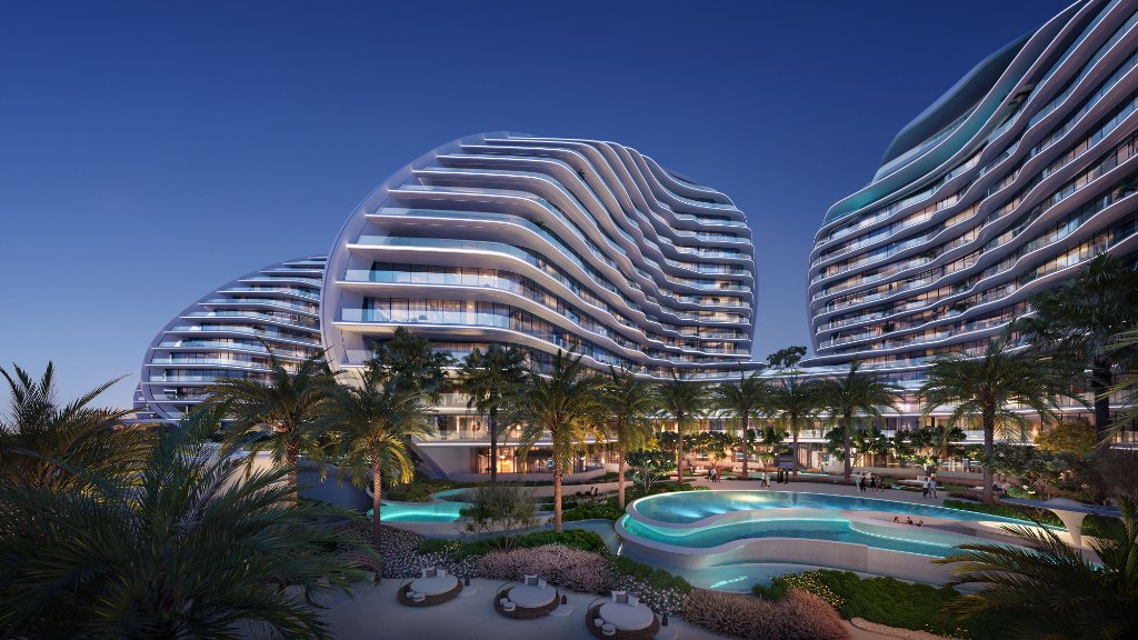 Oystra Residences at Twilight by ZHA Oystra residential buildings at dusk with illuminated lagoon pool by Zaha Hadid Architects