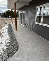 Side patio with stamped concrete, a wood porch post, and sliding glass door