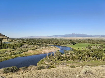 River winding through a green valley toward distant mountains