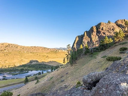 Golden-hour cliffs and pines above a river