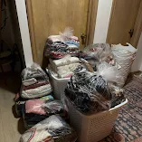 Krista's laundry after Two Chicks service — baskets of neatly folded, plastic-wrapped laundry ready to put away