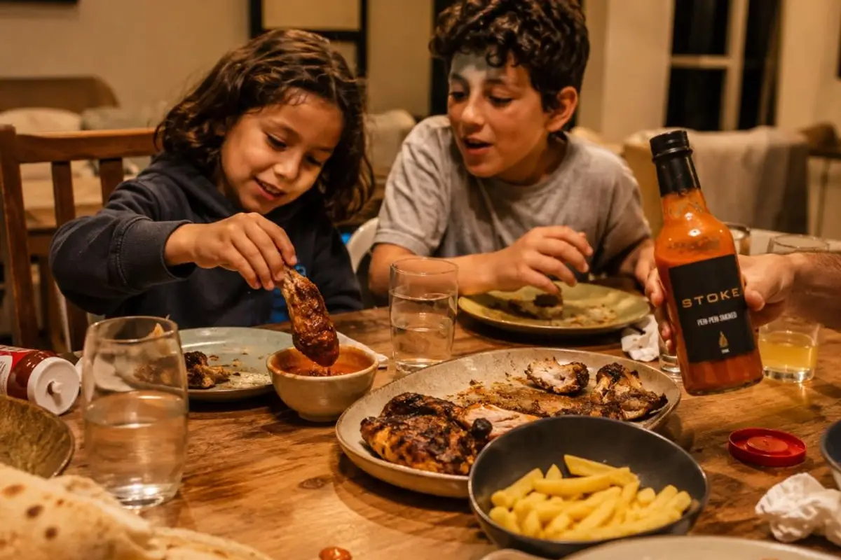 Two children enjoying chicken with STOKE peri-peri sauce