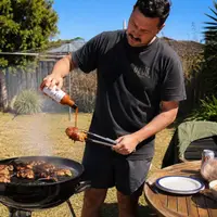 Pouring STOKE sauce on grilled chicken at BBQ