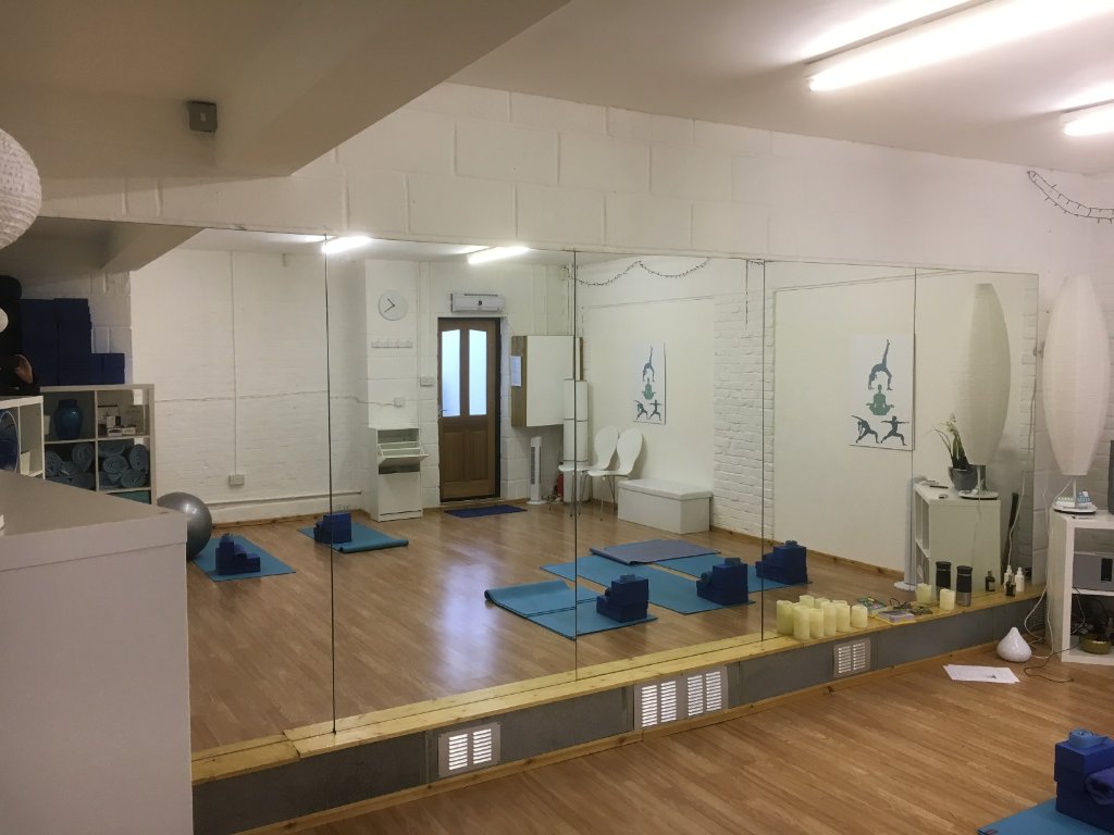 Large floor-to-ceiling gym mirror installation spanning a studio wall