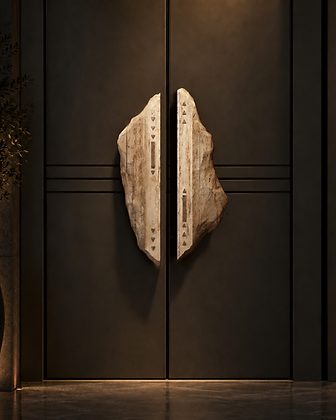 Pair of sculptural natural stone door handles mounted symmetrically on dark paneled double doors