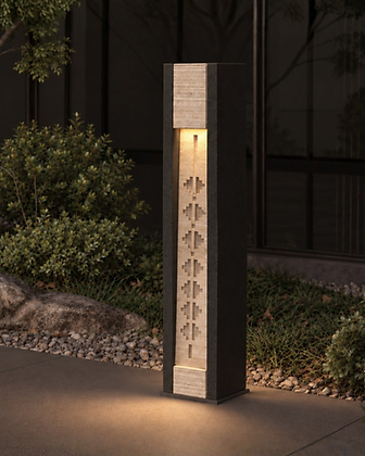 Outdoor stone bollard lantern with warm glowing top in a landscaped garden setting