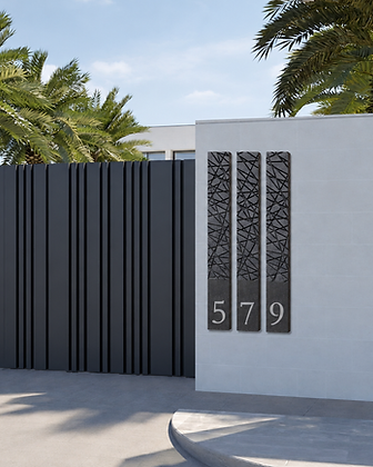 Brushed brass house number plaque with warm backlight mounted on a textured stone wall