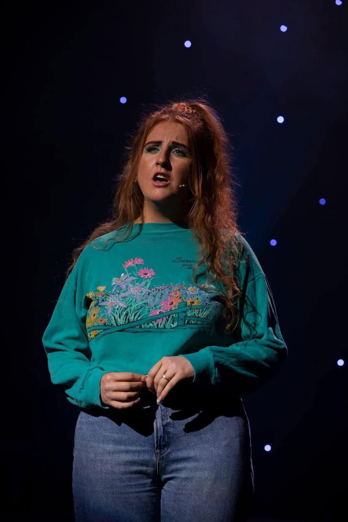 Spotlight student performing on a starlit stage