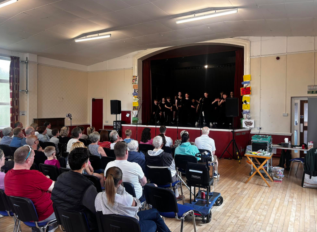 Students performing on stage with audience
