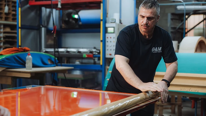 B&M Plastics craftsman hand-finishing a sheet on the workshop floor