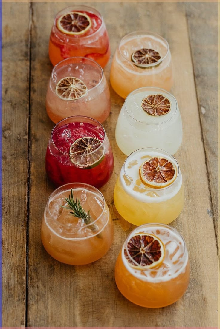 A spread of colorful HIYO adaptogen mocktails on a warm wood surface