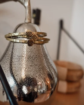 Silver pear decorative object with bangles on a shelf