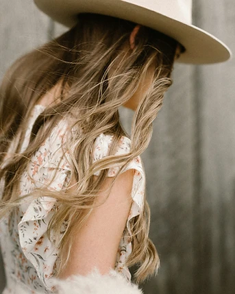 A woman in a wide-brim hat, wandering