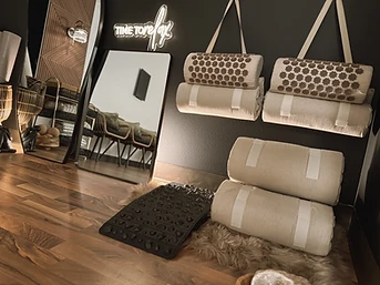 Acupressure mats and bolsters arranged on a faux-fur rug