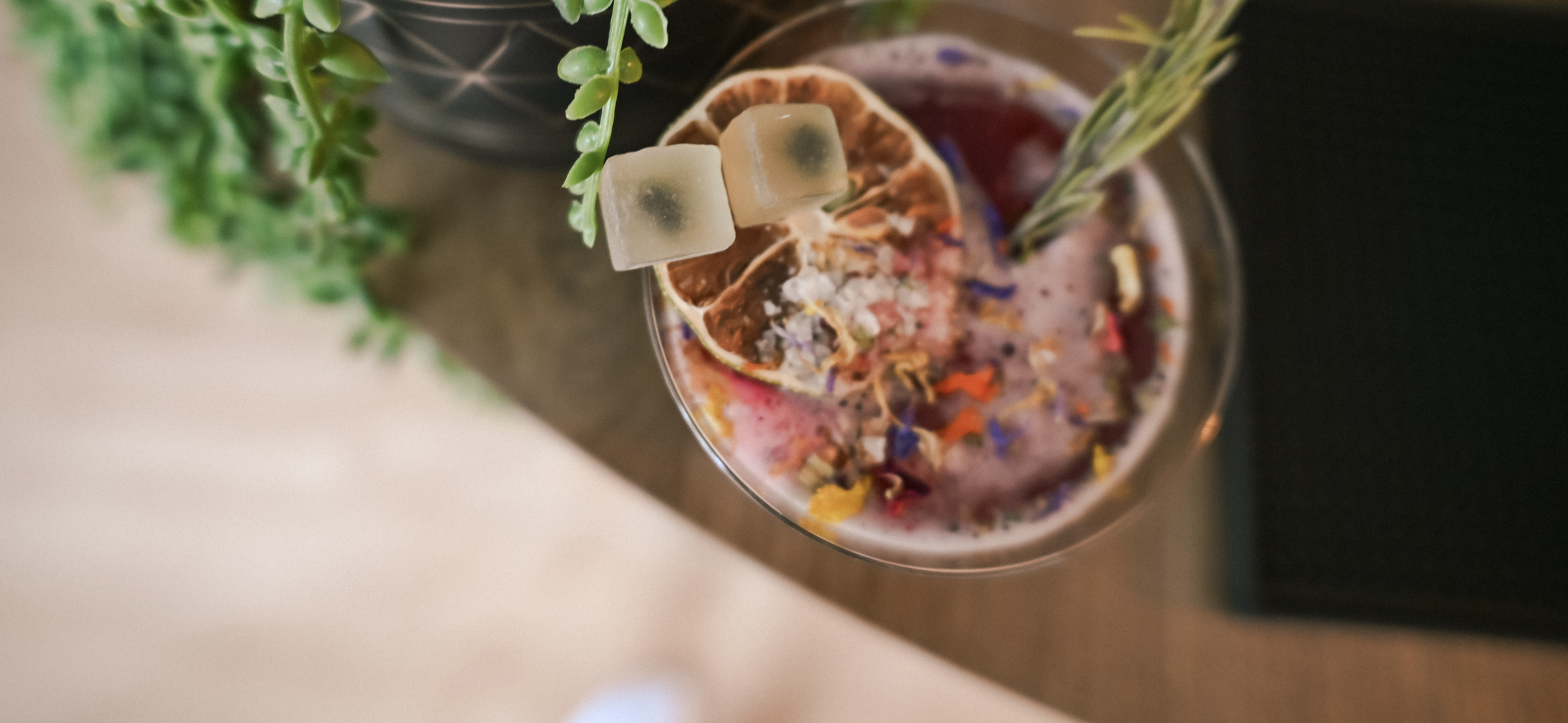 A spread of colorful HIYO adaptogen mocktails on a warm wood surface