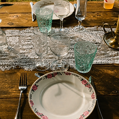 Vaisselle vintage et verres colorés dressés pour un mariage