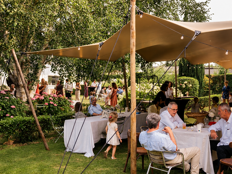 Réception privée organisée sous une tente stretch dans le jardin d'un domaine