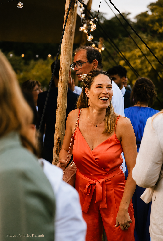 Invitée souriante lors d'un mariage sous une tente de La Tente Normande