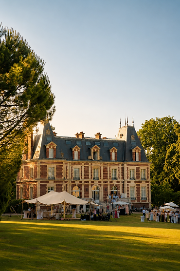 Réception organisée devant un château avec une tente stretch