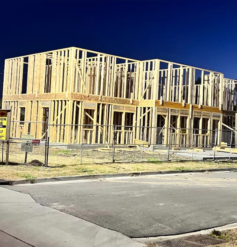 Legacy — construction site framing under blue sky