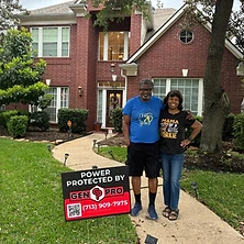 Couple with A&A GenPro power protected sign in front of new Houston area home
