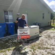 Technician standing next to newly installed Generac standby generator with Suncoast Power installation sign