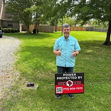 Homeowner giving thumbs up with A&A GenPro sign at Houston Texas brick home