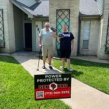 Couple both holding A&A GenPro emergency radio in front of Houston area home with generator sign