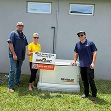 Homeowner and two Suncoast Power Solutions technicians next to installed Generac home backup generator
