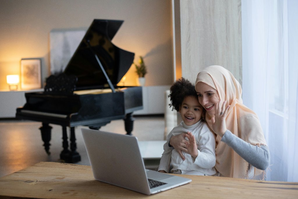 A parent and child joining a virtual piano lesson from home