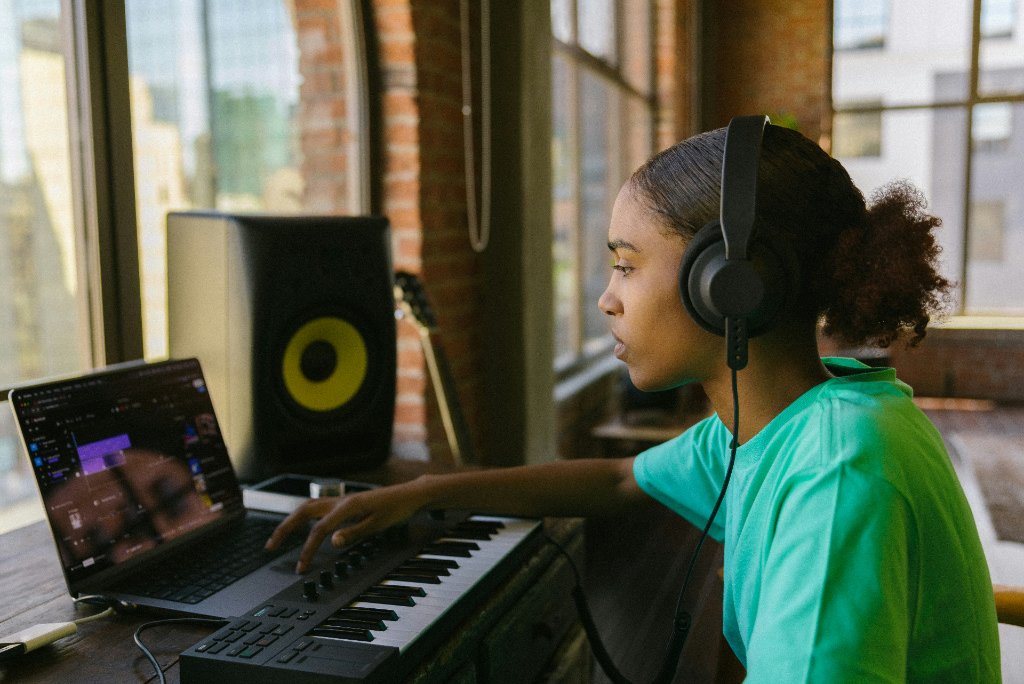 A young musician learning with a laptop and keyboard