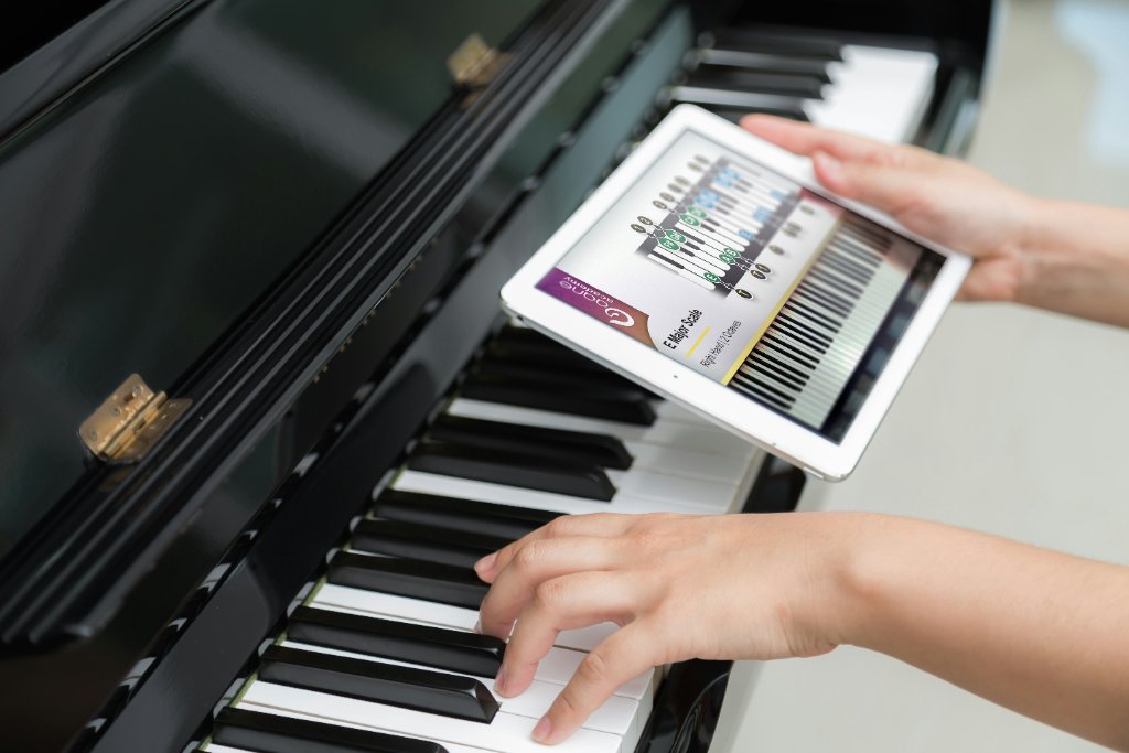 A child learning piano with a digital lesson on a tablet