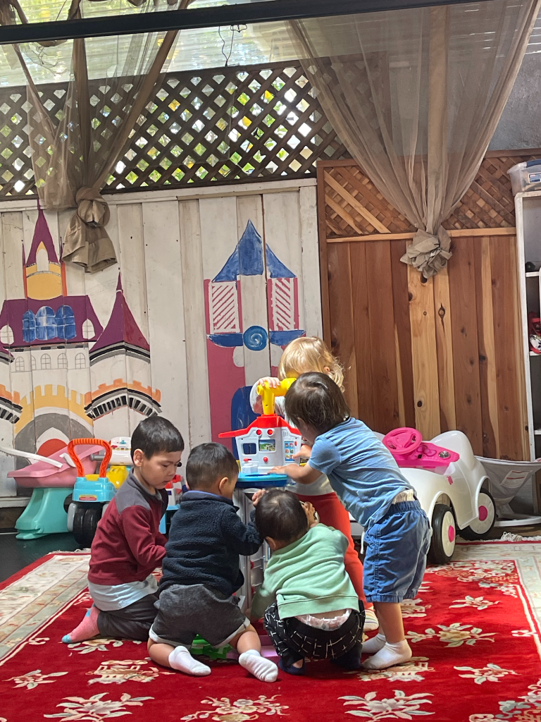 Five children exploring a colorful activity station