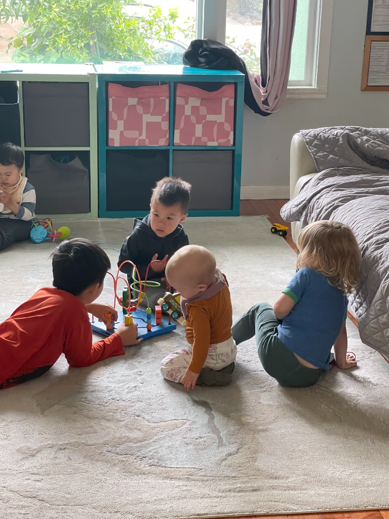 Children gathered around a bead maze toy