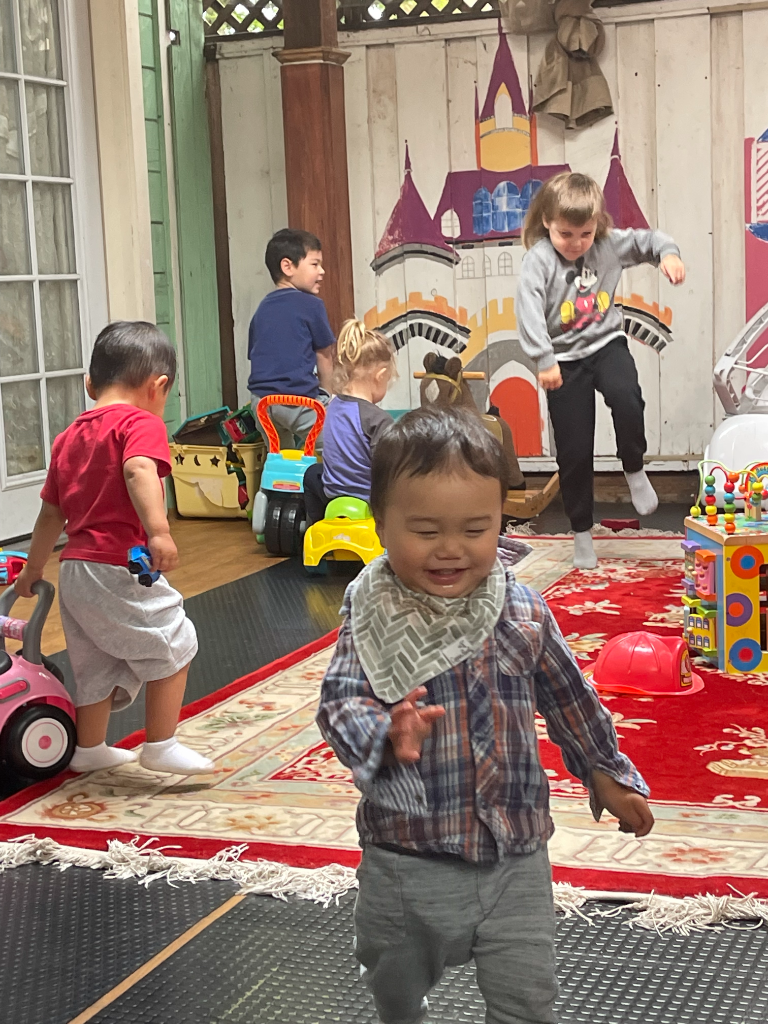Toddlers playing together on the castle-mural rug